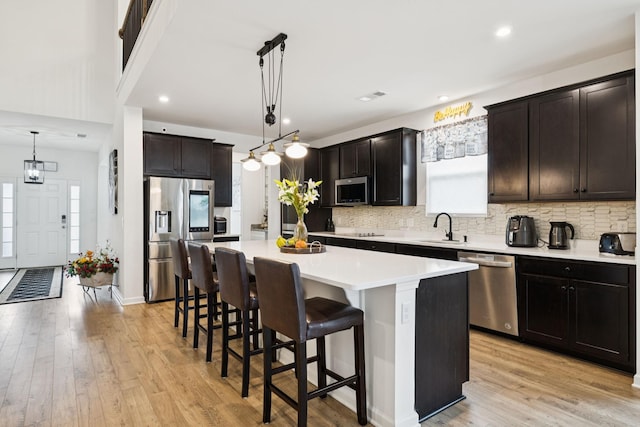 809 Old Blue Ln, Murfreesboro, TN 37130 - kitchen featuring appliances with stainless steel finishes, a center island, a kitchen breakfast bar, light wood-type flooring, and recessed lighting