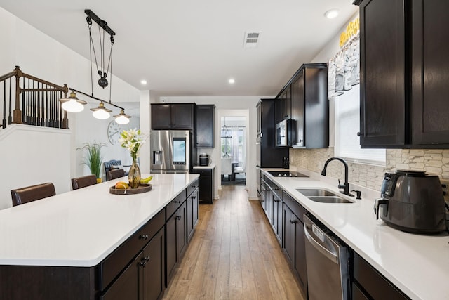 809 Old Blue Ln, Murfreesboro, TN 37130 - kitchen featuring appliances with stainless steel finishes, light countertops, light wood-style flooring, a center island, and hanging light fixtures