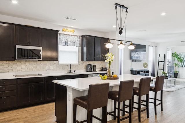 809 Old Blue Ln, Murfreesboro, TN 37130 - kitchen with tasteful backsplash, a kitchen island, a kitchen bar, light wood finished floors, and recessed lighting