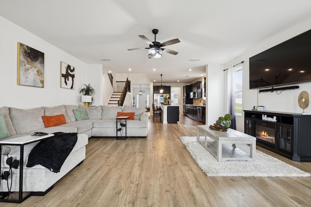 809 Old Blue Ln, Murfreesboro, TN 37130 - living area with stairway, light wood finished floors, a glass covered fireplace, and ceiling fan