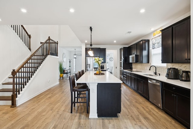 809 Old Blue Ln, Murfreesboro, TN 37130 - kitchen with stainless steel appliances, a kitchen bar, light countertops, light wood-style floors, and recessed lighting
