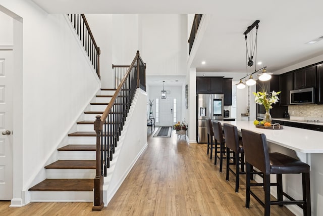 809 Old Blue Ln, Murfreesboro, TN 37130 - kitchen featuring appliances with stainless steel finishes, light countertops, a breakfast bar area, light wood-type flooring, and backsplash