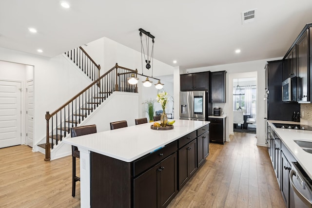 809 Old Blue Ln, Murfreesboro, TN 37130 - kitchen featuring stainless steel appliances, light wood-type flooring, a breakfast bar area, light countertops, and recessed lighting