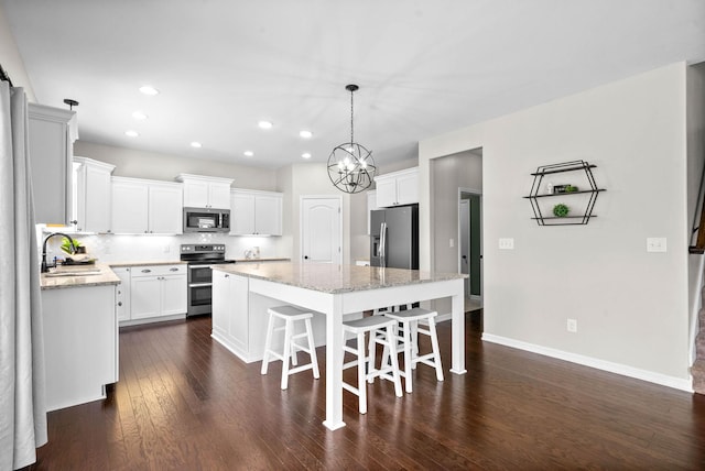 1197 Upland Ter, Clarksville, TN 37043 - kitchen featuring appliances with stainless steel finishes, a kitchen island, dark wood finished floors, recessed lighting, and white cabinets