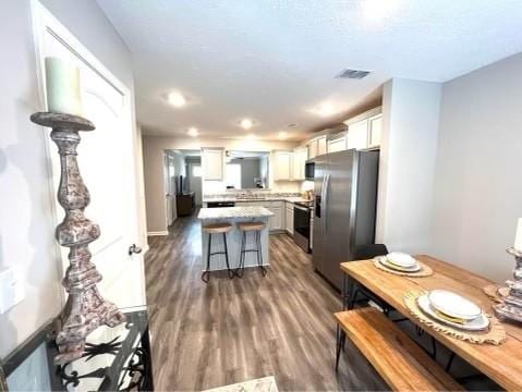 5225 Normandy Cob Dr Unit 33, Murfreesboro, TN 37129 - kitchen with appliances with stainless steel finishes, light countertops, a kitchen breakfast bar, a kitchen island, and wood finished floors