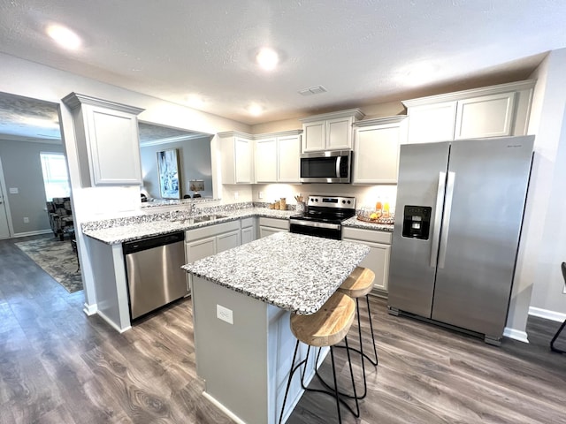 5225 Normandy Cob Dr Unit 33, Murfreesboro, TN 37129 - kitchen with stainless steel appliances, a kitchen island, dark wood-type flooring, a breakfast bar, and light stone counters