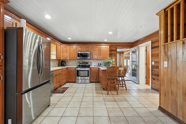 1880 Clydeton Rd, Waverly, TN 37185 - kitchen featuring appliances with stainless steel finishes, light countertops, recessed lighting, wood walls, and light tile patterned flooring