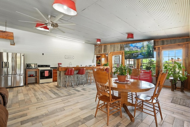 1880 Clydeton Rd, Waverly, TN 37185 - dining area featuring light wood finished floors, a ceiling fan, and wooden walls