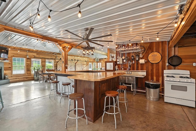 1880 Clydeton Rd, Waverly, TN 37185 - bar with white gas range, wood walls, concrete floors, and a ceiling fan