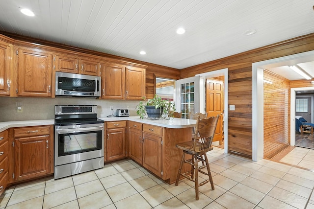 1880 Clydeton Rd, Waverly, TN 37185 - kitchen featuring stainless steel appliances, a peninsula, light countertops, recessed lighting, and brown cabinets