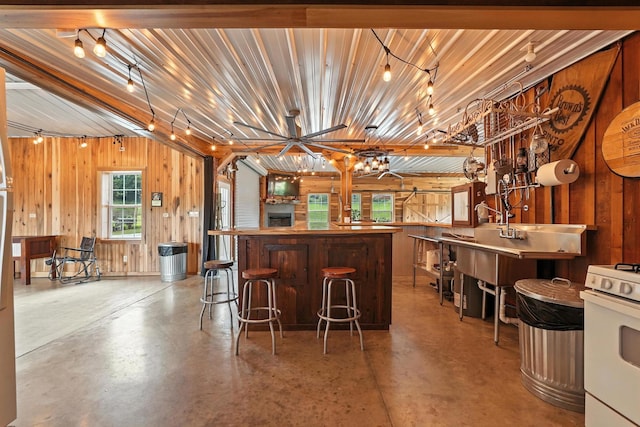 1880 Clydeton Rd, Waverly, TN 37185 - bar area with concrete flooring, white stove, and wood walls