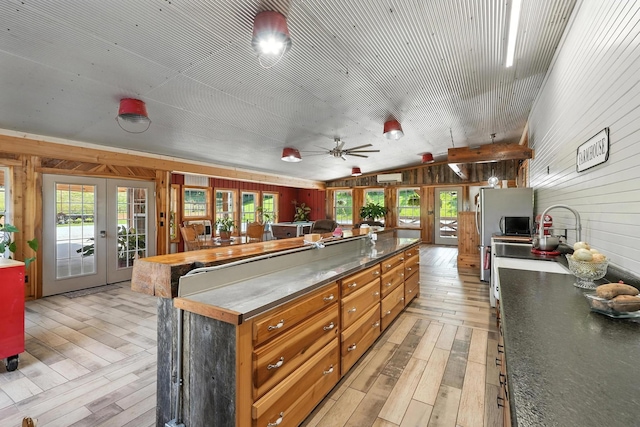1880 Clydeton Rd, Waverly, TN 37185 - kitchen with french doors, wooden walls, light wood-style floors, lofted ceiling, and a center island