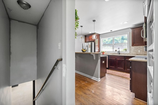 1207 Trotwood Ave, Columbia, TN 38401 - kitchen featuring stainless steel refrigerator with ice dispenser, light wood finished floors, decorative backsplash, decorative light fixtures, and light countertops