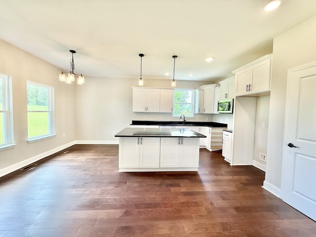 65 Misty Ln, Castalian Springs, TN 37031 - kitchen featuring stainless steel microwave, dark countertops, recessed lighting, white cabinetry, and a center island