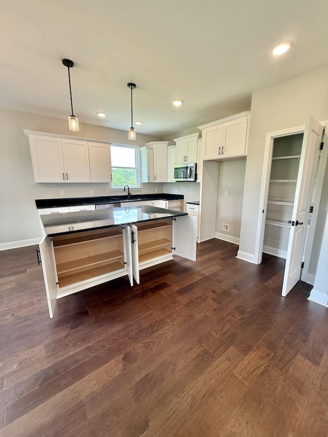 65 Misty Ln, Castalian Springs, TN 37031 - kitchen with stainless steel microwave, white cabinetry, dark countertops, pendant lighting, and dark wood finished floors
