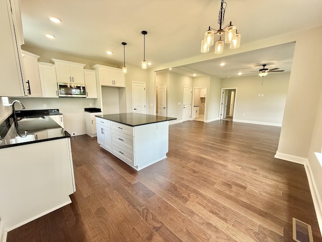 65 Misty Ln, Castalian Springs, TN 37031 - kitchen with stainless steel microwave, dark countertops, white cabinets, recessed lighting, and dark wood-style flooring