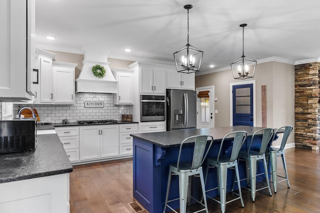 268 Planters Cir, Leoma, TN 38468 - kitchen with appliances with stainless steel finishes, custom exhaust hood, dark countertops, a kitchen island, and tasteful backsplash