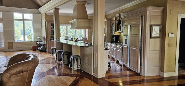395 Allen Rd, Goodlettsville, TN 37072 - kitchen with decorative columns, custom exhaust hood, a breakfast bar area, crown molding, and lofted ceiling