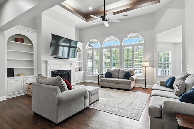 1069 Pleasant Valley Rd, Greenbrier, TN 37073 - living area with dark wood-style floors, a ceiling fan, built in shelves, a towering ceiling, and a premium fireplace