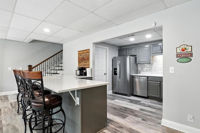 1069 Pleasant Valley Rd, Greenbrier, TN 37073 - kitchen with appliances with stainless steel finishes, a breakfast bar area, light wood-style flooring, a peninsula, and a drop ceiling