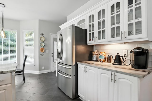 1069 Pleasant Valley Rd, Greenbrier, TN 37073 - kitchen with freestanding refrigerator, backsplash, glass insert cabinets, white cabinetry, and dark tile patterned floors