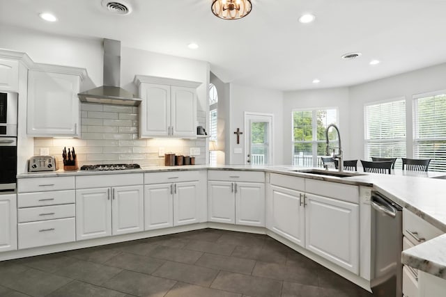 1069 Pleasant Valley Rd, Greenbrier, TN 37073 - kitchen with wall chimney exhaust hood, appliances with stainless steel finishes, decorative backsplash, white cabinets, and recessed lighting
