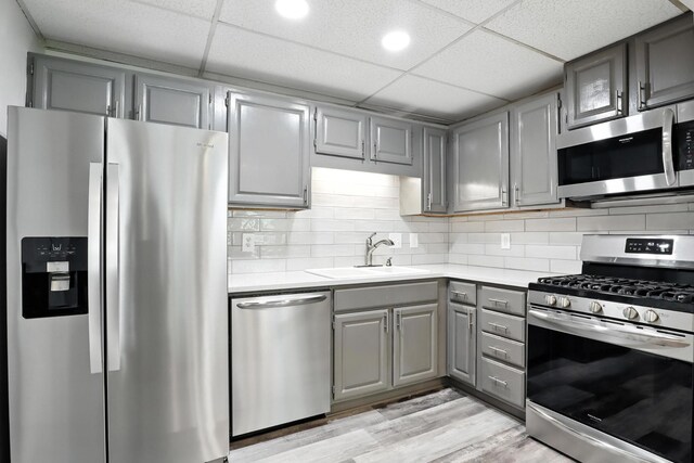 1069 Pleasant Valley Rd, Greenbrier, TN 37073 - kitchen featuring appliances with stainless steel finishes, gray cabinets, light countertops, light wood-style flooring, and a drop ceiling