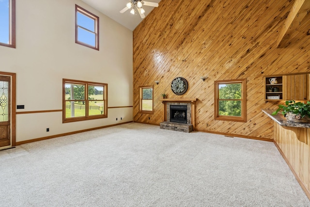 4255 Mcfall Rd, Cumberland City, TN 37050 - unfurnished living room featuring high vaulted ceiling, light carpet, a brick fireplace, wooden walls, and a ceiling fan
