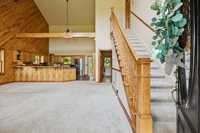 4255 Mcfall Rd, Cumberland City, TN 37050 - entryway featuring high vaulted ceiling, carpet flooring, wooden walls, stairs, and ceiling fan