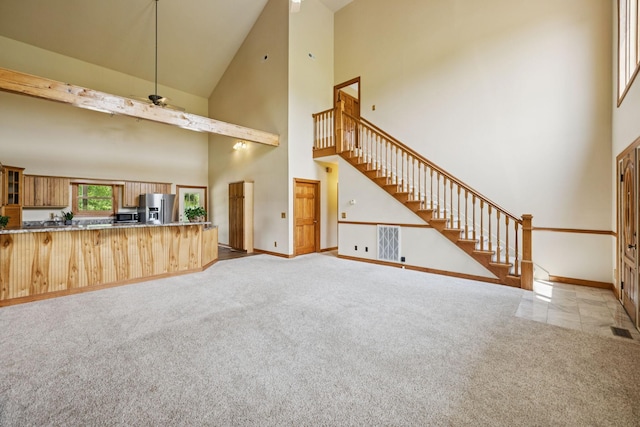 4255 Mcfall Rd, Cumberland City, TN 37050 - unfurnished living room with high vaulted ceiling, stairs, ceiling fan, and light colored carpet