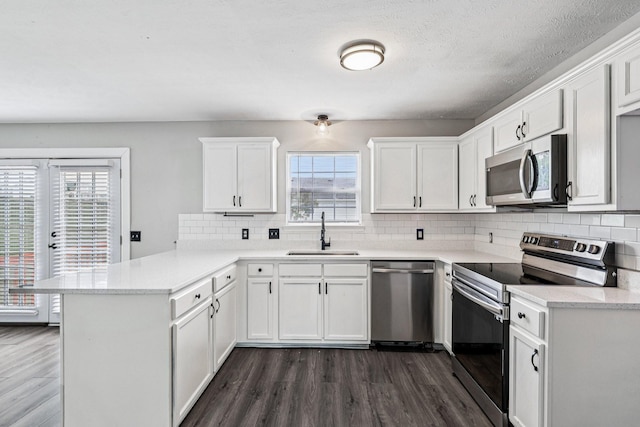 180 Bill Stewart Blvd, La Vergne, TN 37086 - kitchen with appliances with stainless steel finishes, a peninsula, dark wood-style flooring, and white cabinetry