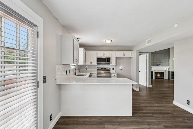 180 Bill Stewart Blvd, La Vergne, TN 37086 - kitchen with appliances with stainless steel finishes, light countertops, a peninsula, white cabinetry, and tasteful backsplash