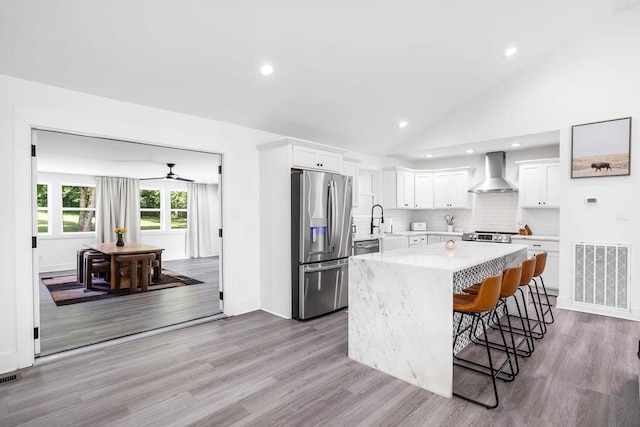 5171 Whites Creek Pike, Whites Creek, TN 37189 - kitchen with stainless steel refrigerator with ice dispenser, wall chimney exhaust hood, recessed lighting, a kitchen breakfast bar, and a center island
