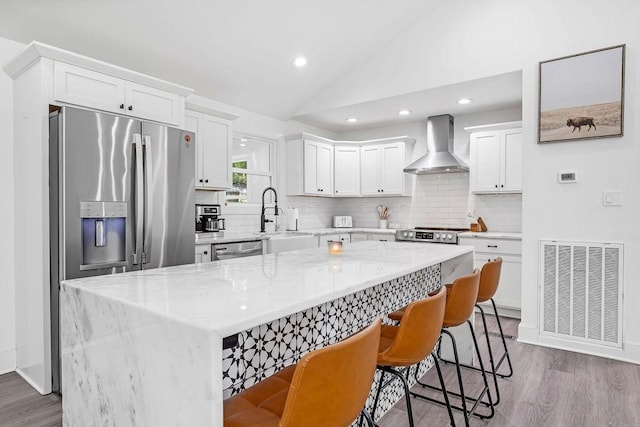 5171 Whites Creek Pike, Whites Creek, TN 37189 - kitchen with wall chimney range hood, tasteful backsplash, wood finished floors, vaulted ceiling, and stainless steel appliances