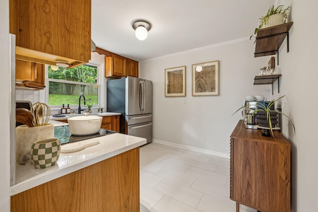204 Eldon Ct, Nashville, TN 37214 - kitchen with freestanding refrigerator, brown cabinetry, light countertops, and crown molding