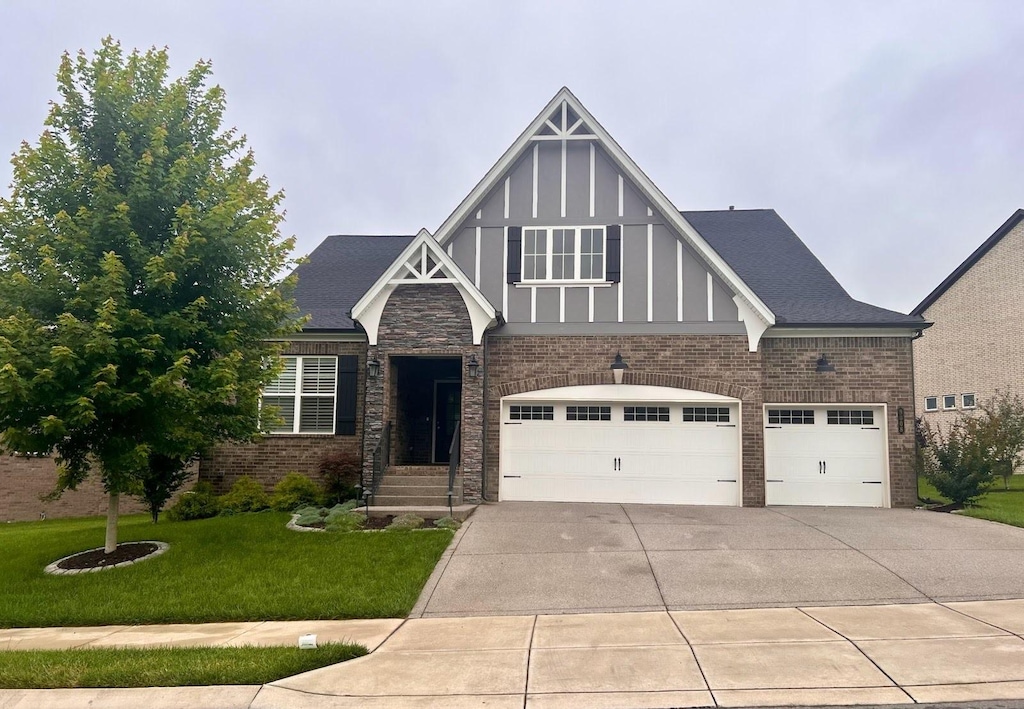 9008 Grayson Cir, Mount Juliet, TN 37122 - english style home featuring concrete driveway, a front yard, a garage, and brick siding