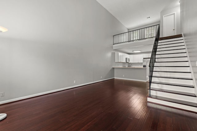 1029 Rachels Square Dr, Hermitage, TN 37076 - unfurnished living room featuring dark wood finished floors, stairway, and a high ceiling
