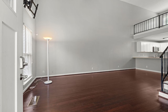 1029 Rachels Square Dr, Hermitage, TN 37076 - unfurnished living room featuring dark wood-style floors, a high ceiling, and stairs