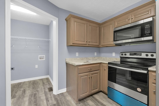 128 N C St, Hillsboro, TN 37342 - kitchen with stainless steel appliances, light wood-style flooring, light countertops, and a textured ceiling