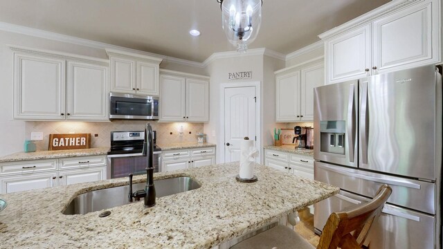 15505 Versailles Rd, Rockvale, TN 37153 - kitchen featuring appliances with stainless steel finishes, a kitchen breakfast bar, white cabinetry, light stone counters, and crown molding