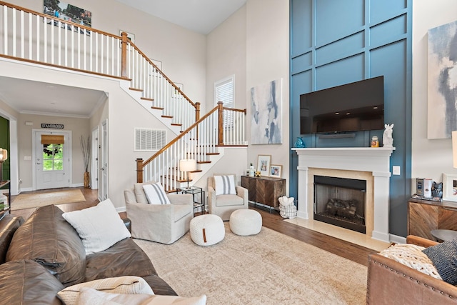 2213 Kirkwall Dr, Nolensville, TN 37135 - living area featuring wood finished floors, stairway, a high ceiling, a fireplace with flush hearth, and crown molding