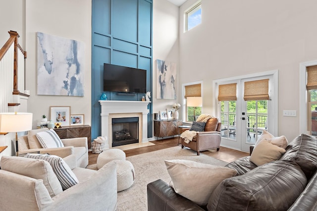 2213 Kirkwall Dr, Nolensville, TN 37135 - living room with healthy amount of natural light, wood finished floors, a towering ceiling, a fireplace with flush hearth, and french doors