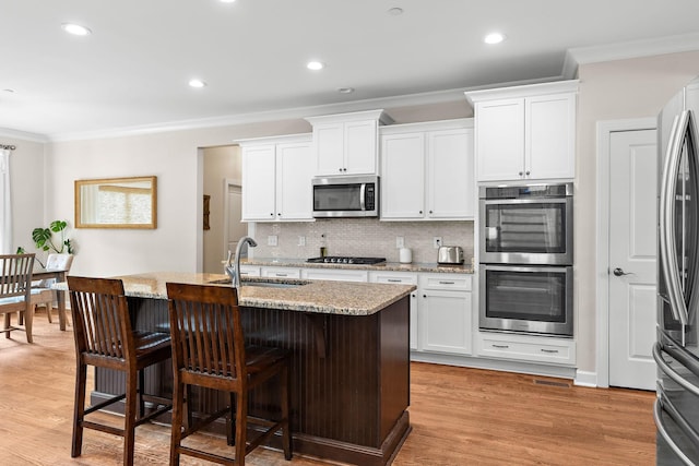 2213 Kirkwall Dr, Nolensville, TN 37135 - kitchen featuring stainless steel appliances, crown molding, light stone counters, a breakfast bar area, and tasteful backsplash