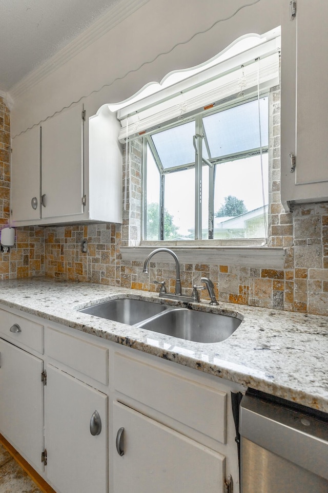 3405 Elder Mountain Rd, Chattanooga, TN 37419 - kitchen with stainless steel dishwasher, ornamental molding, backsplash, white cabinetry, and light stone counters