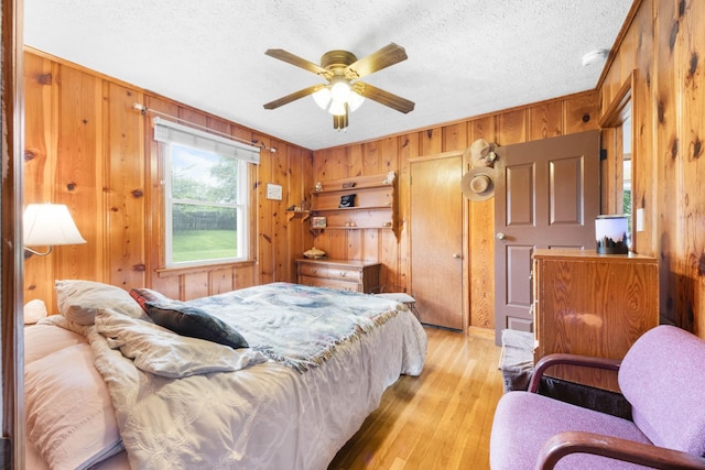 19 Garth Dr, Clarksville, TN 37040 - bedroom featuring wooden walls, light wood-type flooring, a textured ceiling, and a ceiling fan