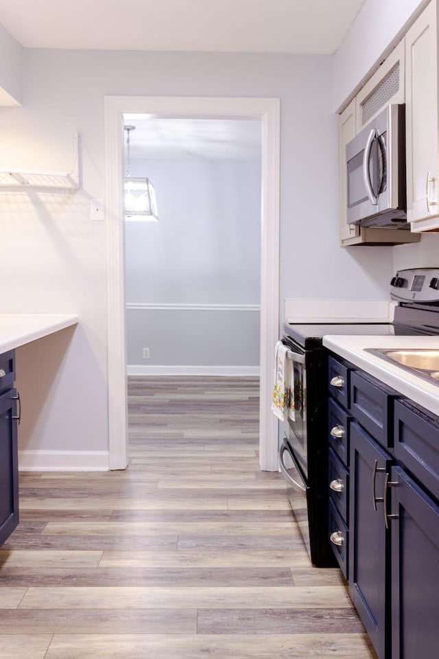 1280 Middle Tennessee Blvd Unit E14, Murfreesboro, TN 37130 - kitchen with stainless steel appliances, light wood-style floors, blue cabinetry, and light countertops
