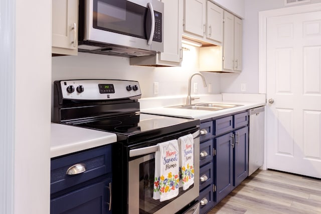 1280 Middle Tennessee Blvd Unit E14, Murfreesboro, TN 37130 - kitchen with appliances with stainless steel finishes, blue cabinets, light countertops, white cabinetry, and light wood-style flooring