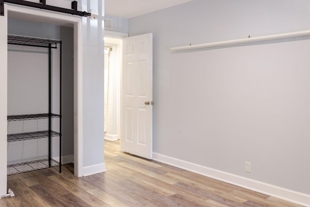 1280 Middle Tennessee Blvd Unit E14, Murfreesboro, TN 37130 - unfurnished bedroom with light wood finished floors and a barn door