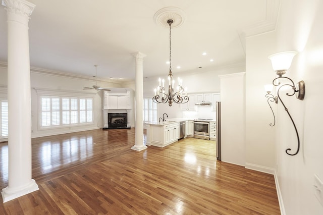 1176 Fairvue Village Ln, Gallatin, TN 37066 - unfurnished living room with a fireplace with raised hearth, ceiling fan, light wood-style flooring, decorative columns, and ornamental molding