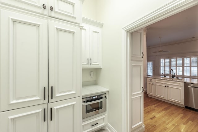 1176 Fairvue Village Ln, Gallatin, TN 37066 - kitchen featuring stainless steel appliances, light wood-type flooring, light stone countertops, ornamental molding, and ceiling fan
